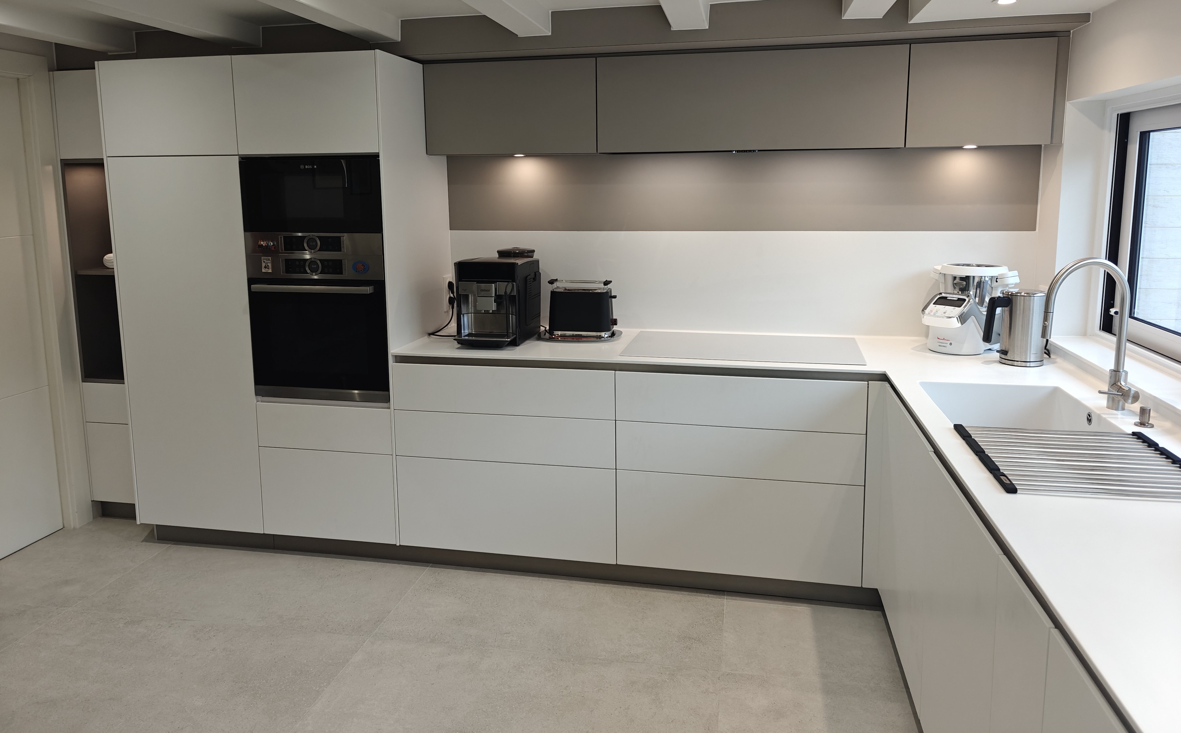 Image d'une cuisine blanche en coin réalisée par la menuiserie Ennesser